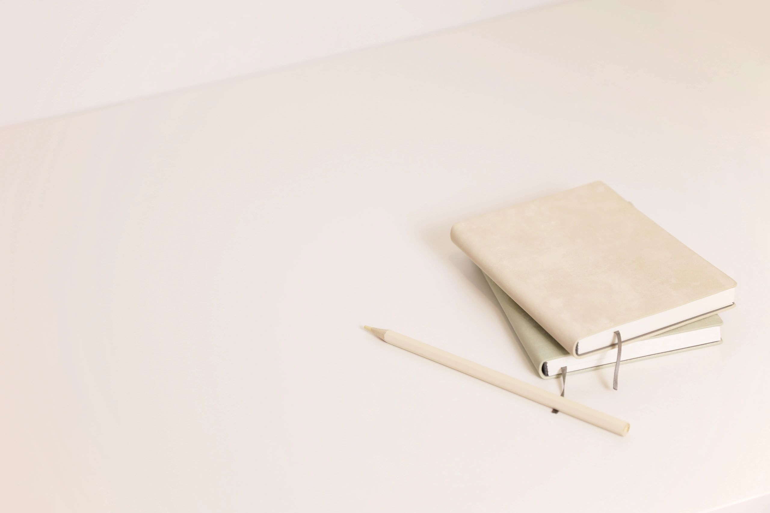 Minimal notebooks on a neutral desk representing reflection and planning